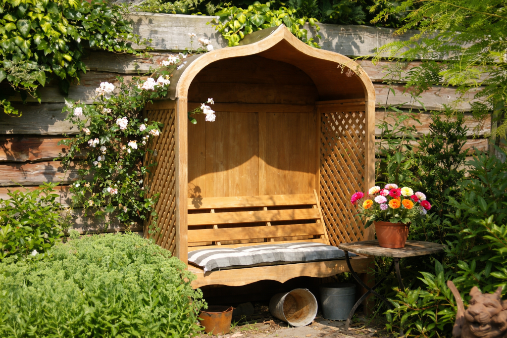 Kleiner Holzpavillon mit Bank und Zinkdach als dekorative Gartensitzecke
